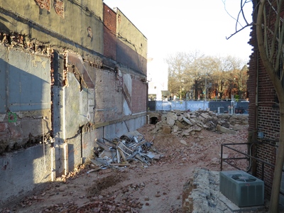 You can see shadows of old staircases angled up between floors. But what is that dark little archway near the sidewalk?