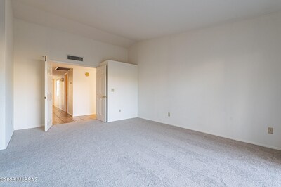 Primary bedroom standing at the glass door-wall. The bump-out next to the doorway is the back side of the hall closet.